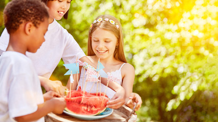 Kinder teilen Wassermelone bei Kindergeburtstag