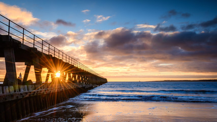 Sunburst on River Blyth Harbour West Pier, as the river reaches the North Sea between the piers in Northumberland