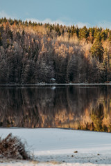 Incredible reflections in the lake with beautiful sunset light. The first frosts in Scandinavia, Finland