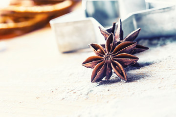 Star anise cookie cutter cinnamon and flour on baking board. Christmas baking utensil and holiday...
