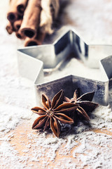 Star anise cookie cutter cinnamon and flour on baking board. Christmas baking utensil and holiday concept