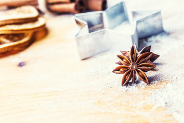 Star anise cookie cutter cinnamon and flour on baking board. Christmas baking utensil and holiday concept