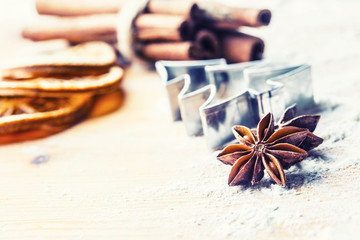 Star anise cookie cutter cinnamon and flour on baking board. Christmas baking utensil and holiday...