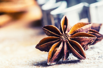 Star anise cookie cutter cinnamon and flour on baking board. Christmas baking utensil and holiday...