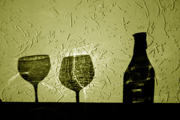 wine bottle and two glasses shadow in yellow