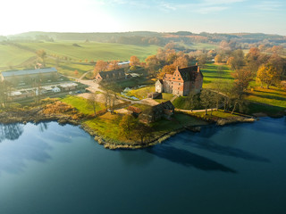 Historisches wunderschönes Schloss Ulrichshusen in der Mecklenburgischen Schweiz in Mecklenburg-Vorpommern im Frühling, farbenfroh, Blick vom See mit der Drohne 