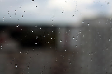 Rain drops on window with blured background.