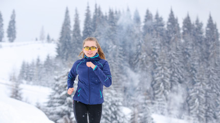 Fototapeta na wymiar Teenage girl running on winter mountain trail