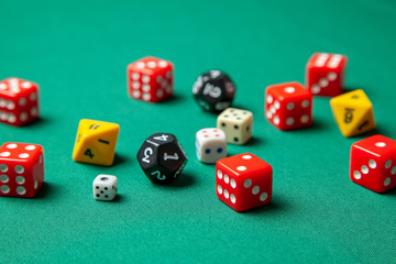 Collection of colored gaming dice cubes on green table
