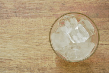 Obraz na płótnie Canvas ice cube in drinking glass on table