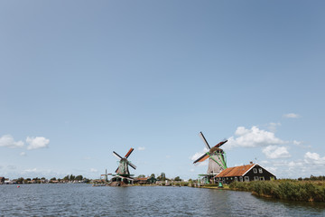 Traditional dutch windmills and houses near the canal in Zaanse Schans, Netherlands.