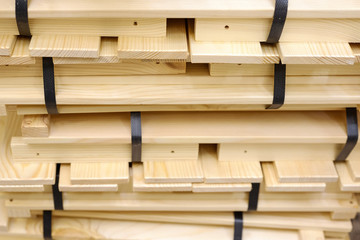 Wooden bales of strips packed with plastic tape on wooden beams.