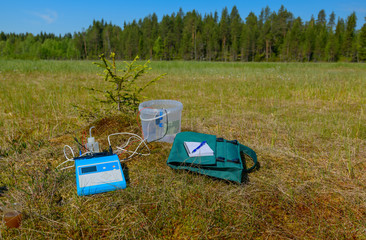 The scientific equipment is on a investigated biotope. The pH meter, the field journal with pen,...
