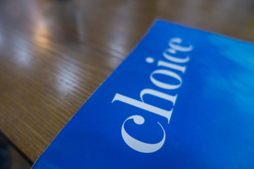 a book cover written 'choice' on the wooden table