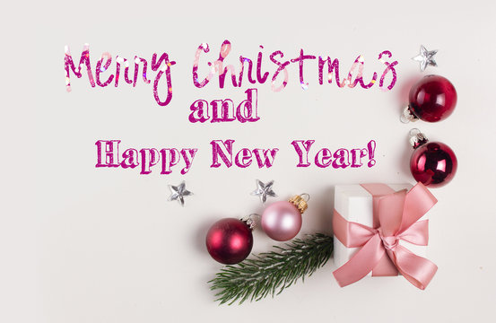 Christmas flat lay top view border with pink and violet glass balls and gift box with Merry Christmas and Happy New Year greetings