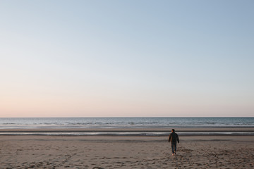 Fototapeta na wymiar man walking on the beach, north sea