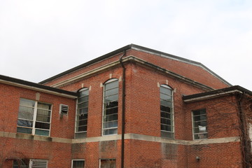 Abandoned and boarded up brick mental asylum hospital building exterior