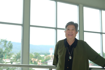 Fototapeta premium asian elder woman resting relaxing on balcony terrace. elderly senior leisure lifestyle