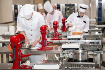 Female chefs prepare pastry in the kitchen of the hotel or restaurant. Blured background