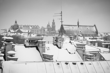 Fototapeta premium Krakow in Christmas time, aerial view on snowy roofs in central part of city. Wawel Castle and the Cathedral. BW photo. Poland. Europe.