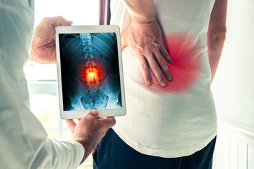 Doctor holding a digital tablet with x-ray-of back pain of a patient