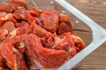 Meat beef cut into pieces in a plastic tray. Close up