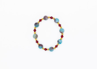 blue and red colored and variously sized beads bracelet on white background