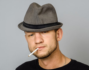 Man with cigarette on gray