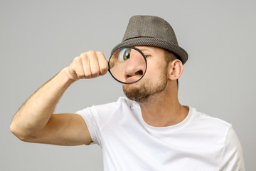 Astonished man looking through a magnifying glass