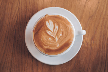 Coffee with cream on a wood table 