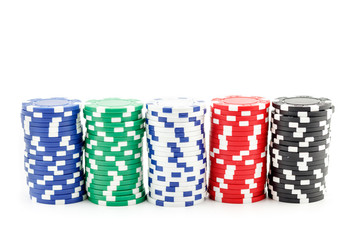 Casino games concept,Stacks of poker chipson gamble table including red, black, white, green and blue on a white background.