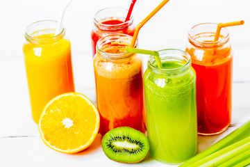 Fresh detox juices in glass bottles on white background