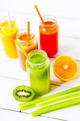 Fresh detox juices in glass bottles on white background