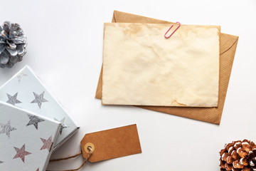 Christmas composition. Christmas gifts, old vintage envelope and paper, pine cones. Top view, flat lay, copy space, mockup..