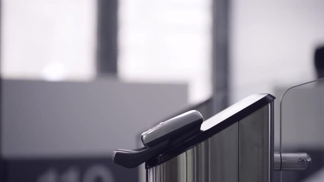 Close-up view to turnstile. Frame. Electronic access control security system indoor side view. Close-up view of hand of man applying pass to turnstile