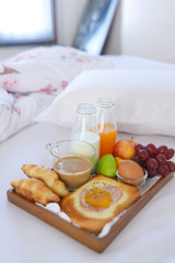 Breakfast on bed with coffee, croissants Window light
