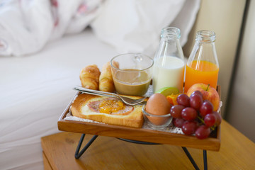 Breakfast on bed with coffee, croissants Window light
