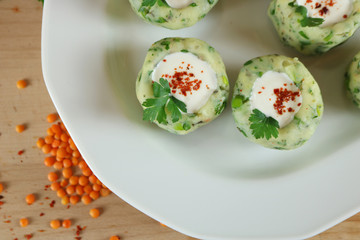 Fototapeta na wymiar Potato balls with chive, parsley, and spices serving with fresh yogurt