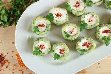 Potato balls with chive, parsley, and spices serving with fresh yogurt