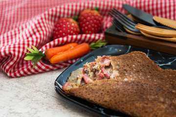 Black wheat and wheat galette topped with cooked ham and emmental cheese