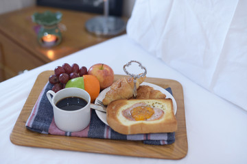 Breakfast on bed with coffee, croissants Window light
