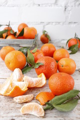 Tangerines with leaves in a wooden box. Vertical.