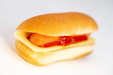 Hot dog with ketchup and cheese on white