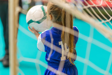 kids in blue teams train and play football in the hall. girls and boys play together soccer.