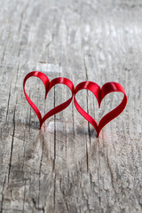 Fototapeta premium Two ribbon hearts on wood