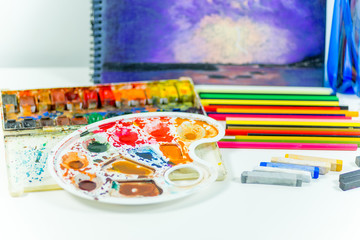 work space on a table with pencils and paintbrushes