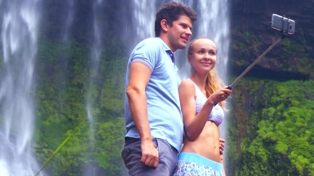 closeup guy girl make selfie smiling at foamy waterfall