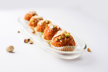 Carrot Halwa Laddu or sweet balls,  served in a plate with dry fruits toppings. selective focus
