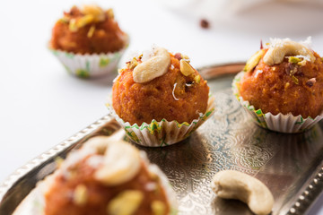 Carrot Halwa Laddu or sweet balls,  served in a plate with dry fruits toppings. selective focus