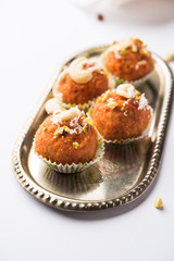 Carrot Halwa Laddu or sweet balls,  served in a plate with dry fruits toppings. selective focus